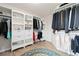 A well-organized walk-in closet with custom shelving, drawers, and hanging space, plus a round decorative area rug at 9169 Fox Fire Way, Highlands Ranch, CO 80129