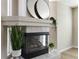 Modern fireplace with tile surround, decorative mirror, and hardwood floors at 9169 Fox Fire Way, Highlands Ranch, CO 80129