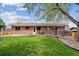 Charming brick home featuring a spacious backyard with a deck and lush green lawn, perfect for outdoor entertaining at 12752 W Asbury Pl, Lakewood, CO 80228