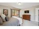 Bedroom with dresser, wall-mounted tv, and neutral color scheme at 12752 W Asbury Pl, Lakewood, CO 80228