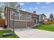 Well-kept home featuring a spacious driveway and attached garage, set on a beautifully landscaped lot with mature trees at 12752 W Asbury Pl, Lakewood, CO 80228