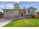 Charming exterior featuring a well-maintained lawn, brick accents, and a cozy entrance at 12752 W Asbury Pl, Lakewood, CO 80228