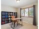 Bright home office with large window, neutral carpet, desk and bookcase at 12752 W Asbury Pl, Lakewood, CO 80228