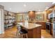 Bright kitchen with wood cabinets, granite counters, island with seating, and stainless steel appliances at 12752 W Asbury Pl, Lakewood, CO 80228