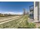 Backyard area includes a sidewalk along the hill and a building with blue balconies at 1351 S Cathay Ct # 102, Aurora, CO 80017