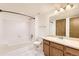 Bright bathroom features a tub with shower, toilet, vanity with wood cabinets, and light colored tile at 1351 S Cathay Ct # 102, Aurora, CO 80017