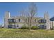 Exterior view of a building featuring multiple balconies, neutral-colored siding, and partial tree coverage at 1351 S Cathay Ct # 102, Aurora, CO 80017
