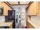 Efficient kitchen layout with wood cabinets and appliances and tile floor flowing through to the living room at 1351 S Cathay Ct # 102, Aurora, CO 80017