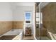 A modern bathroom featuring a soaking tub, walk-in shower, and a chandelier at 12972 Uinta Ct, Thornton, CO 80602
