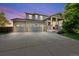 Charming two-story home showcasing a manicured lawn and a spacious three-car garage with stone accents on the facade at 12972 Uinta Ct, Thornton, CO 80602