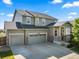 Charming two-story home showcasing a manicured lawn and a spacious three-car garage with stone accents on the facade at 12972 Uinta Ct, Thornton, CO 80602