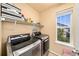 Well-organized laundry room with modern machines and natural light at 12972 Uinta Ct, Thornton, CO 80602