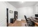 Comfortable office space featuring a wooden desk, plush carpeting, and ample storage with stylish black shelving at 12972 Uinta Ct, Thornton, CO 80602