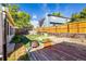 Fenced backyard with a tiered garden, wooden deck and partial lawn at 9805 Garrison Ct, Broomfield, CO 80021