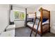 Bright bedroom with a wooden bunk bed, carpet flooring, and natural light from a large window at 9805 Garrison Ct, Broomfield, CO 80021