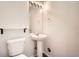 Small bathroom featuring white fixtures, pedestal sink and dark flooring at 5547 Himalaya Rd, Denver, CO 80249