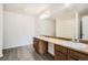 Bathroom featuring double sinks, large mirror, and tiled floors at 5547 Himalaya Rd, Denver, CO 80249