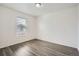 Bright bedroom features new gray wood-style flooring and a window offering natural light at 5547 Himalaya Rd, Denver, CO 80249