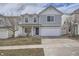 Charming two-story home featuring gray siding, a two-car garage, and a well-maintained front yard at 5547 Himalaya Rd, Denver, CO 80249