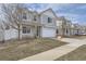 Two-story home featuring gray siding, a two-car garage, and a 