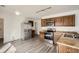 Well-lit kitchen featuring stainless steel appliances, wood cabinets, and durable gray flooring at 5547 Himalaya Rd, Denver, CO 80249
