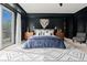 Modern bedroom featuring a dark accent wall, stylish rug, and walk-in closet at 25312 E Glasgow Pl, Aurora, CO 80016