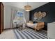 Stylish bedroom with a daybed, accent wall, and unique light fixture at 25312 E Glasgow Pl, Aurora, CO 80016