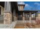 Home featuring a stone front porch supported by stone columns and a black front door at 25312 E Glasgow Pl, Aurora, CO 80016