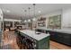 Spacious kitchen featuring an island with bar seating, open shelving, and modern appliances at 25312 E Glasgow Pl, Aurora, CO 80016