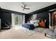 Well-lit bedroom with a dark accent wall, ceiling fan, and a comfortable seating area at 25312 E Glasgow Pl, Aurora, CO 80016