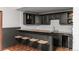 Finished basement wet bar area boasts granite counters, dark cabinets, and seating for four at 25312 E Glasgow Pl, Aurora, CO 80016