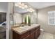 Well-lit bathroom featuring a double sink vanity, tile countertop, and ample lighting at 11007 Meadowvale Cir, Highlands Ranch, CO 80130