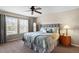 Comfortable bedroom with large windows, a ceiling fan, and a well-coordinated bedding ensemble at 11007 Meadowvale Cir, Highlands Ranch, CO 80130