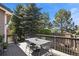 Outdoor deck furnished with a table and chairs surrounded by lush trees and greenery, ideal for outdoor relaxation at 11007 Meadowvale Cir, Highlands Ranch, CO 80130