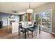 Bright dining area featuring a glass-top table, modern light fixture, and sliding doors to an outdoor deck at 11007 Meadowvale Cir, Highlands Ranch, CO 80130