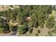Aerial view showcasing a home nestled amongst a plethora of beautiful, mature trees at 2235 Stonecrop Way, Golden, CO 80401