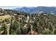Scenic aerial view of a home nestled among lush trees and mountains in the distance at 2235 Stonecrop Way, Golden, CO 80401