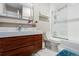Modern bathroom featuring a wood grain vanity, white tile shower, and white marble floor at 2235 Stonecrop Way, Golden, CO 80401