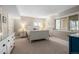 Well-lit bedroom with a queen-sized bed, neutral colored walls and carpet, and three windows at 2235 Stonecrop Way, Golden, CO 80401