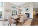 Bright dining room with a fireplace, modern lighting, a full bar, and access to an outdoor deck at 2235 Stonecrop Way, Golden, CO 80401