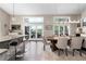 Open-concept dining area with bar seating, hardwood floors, modern lighting, and glass doors to the outdoor deck at 2235 Stonecrop Way, Golden, CO 80401
