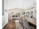 A spacious dining area features a long table, chandelier, and bar seating with a scenic view from the windows at 2235 Stonecrop Way, Golden, CO 80401