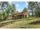 Expansive two-story home with a spacious deck overlooking a lush green lawn and surrounded by towering trees at 2235 Stonecrop Way, Golden, CO 80401