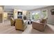 Bright living room with neutral carpet, fireplace, and a view of lush trees through large glass doors at 2235 Stonecrop Way, Golden, CO 80401