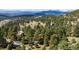 Aerial view capturing the serene mountain setting and homes nestled among the trees at 2235 Stonecrop Way, Golden, CO 80401
