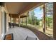 Under deck patio with stone columns and a view of rolling hills at 2235 Stonecrop Way, Golden, CO 80401