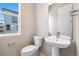 Modern powder room with pedestal sink, toilet, mirror, and window with natural light at 1727 W 166Th Ave, Broomfield, CO 80023