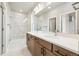 Primary bathroom featuring double vanity, quartz countertop, walk-in shower, and natural light at 1727 W 166Th Ave, Broomfield, CO 80023