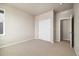 Cozy bedroom with neutral carpet, built-in closet, and a door leading to a hallway at 1727 W 166Th Ave, Broomfield, CO 80023