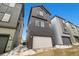 Exterior view of a modern three-story home featuring dark wood paneling and an attached two-car garage at 1727 W 166Th Ave, Broomfield, CO 80023